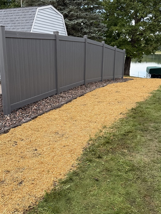 New gray vinyl privacy fence with landscaped border in Chetek, WI