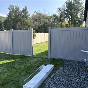 Gray vinyl privacy fence and gate installed beside Chippewa Falls home