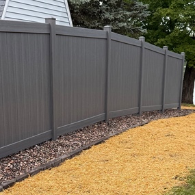 Gray vinyl privacy fence installation along backyard in Chetek, WI