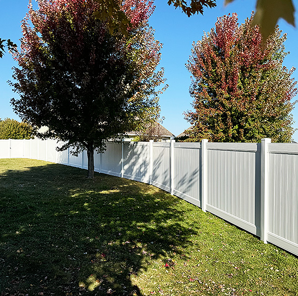Fenced backyard with green lawn